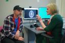 Consultant Dr Heather Shaw speaking to patient Steve Young, with an MRI of his brain on the screen, during a consultation at University College Hospital Macmillan Cancer Centre in London (Jordan Pettitt/PA)