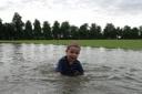 Joshua Thorn, 3, takes a dip in what is normally a cricket pitch in Beverley Park, New Malden