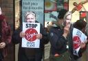 Protesters wearing Richard Branson masks outside the Virgin Media shop in Walthamstow