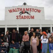 Residents facing eviction in front of the iconic greyhound racing stadium sign. Image: Steward Caine
