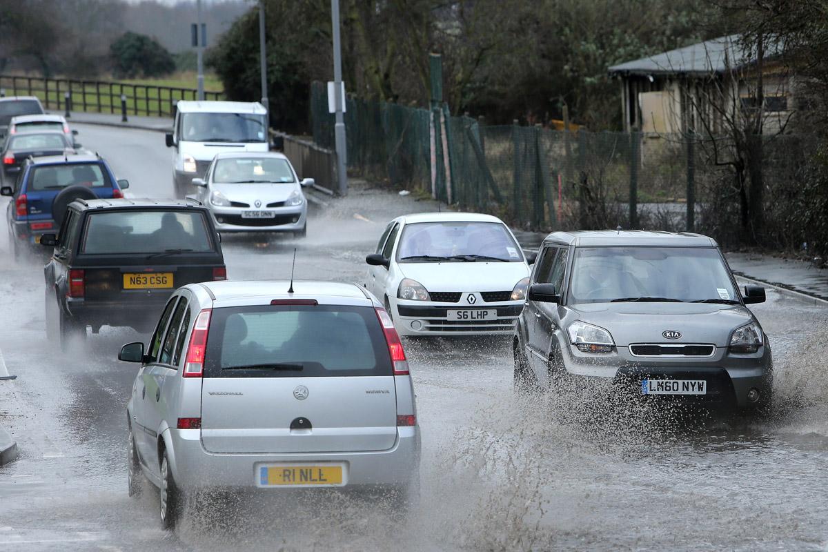 Traffic drives through flooding on Sewardstone Road between Hawkwood Crescent and Sewardstone Gardens. Chingford. (7/2/2013) EL75086_4