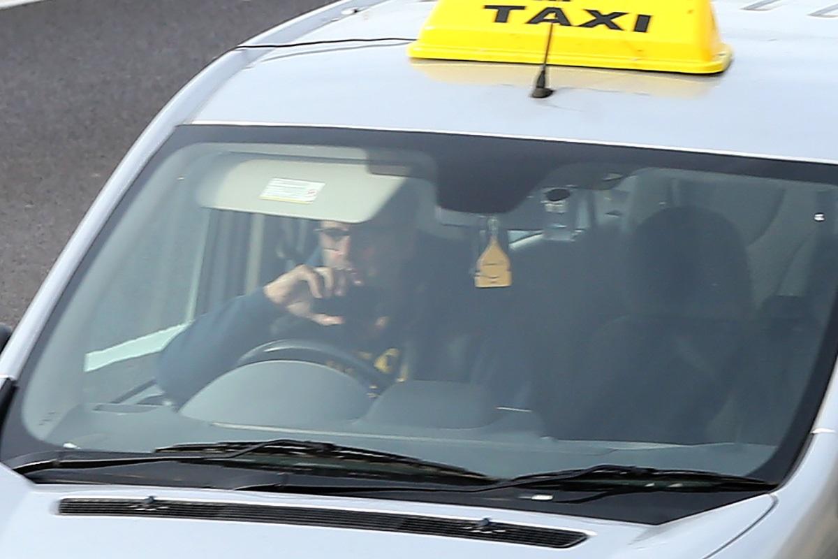 This taxi driver is holding the phone horizontally - even though he should be keeping his eyes on the road
