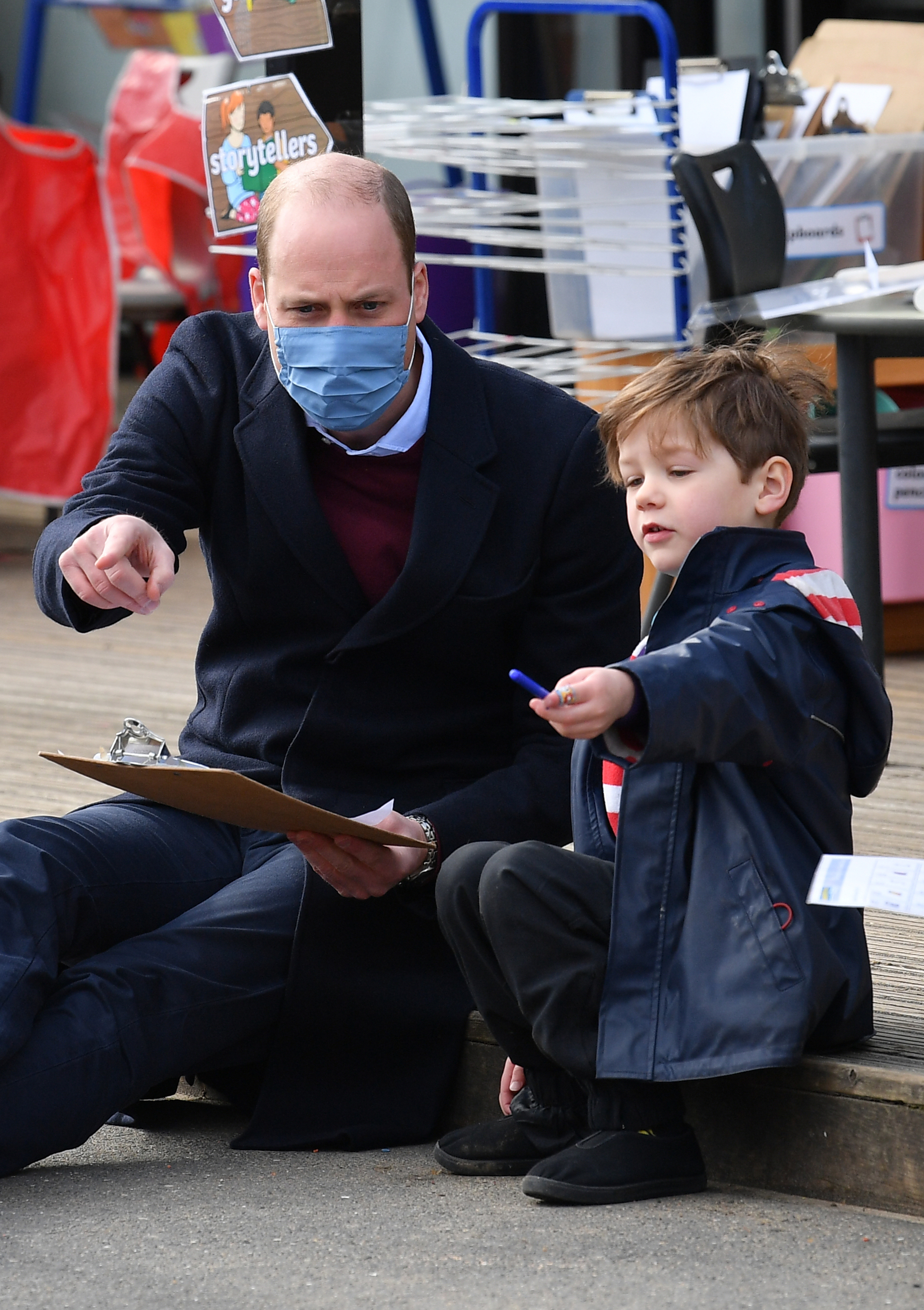 The Duke of Cambridge plays with a child in the playground during a visit to School 21. Photo: PA