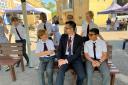 Mr Louis Taylor, Head teacher of St Aubyn's School, sitting with pupils.