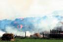 BLAZING BALES: Thousands of straw bales went up in flames when a fire broke out at Hill Farm, Abridge, on Bank Holiday 