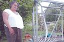 Jacq Dodman stands by what is left of her vandalised greenhouse and garden furniture (E5002-8)