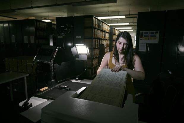 East London and West Essex Guardian Series: Laura Gowing, a Findmypast technician, scanning individual pages of the 30,000 volumes of the 1921 census (Mikael Buck/Findmypast/PA)