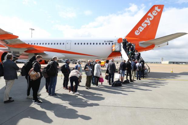East London and West Essex Guardian Series: People queue to board an EasyJet plane. (PA)