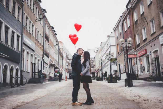 East London and West Essex Guardian Series: A couple embracing on the street in front of heart balloons. Credit: Canva