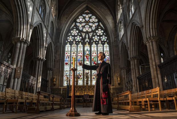 East London and West Essex Guardian Series: Very Reverend John Dobson Dean of Ripon lights a candle to mark the second anniversary of the first national coronavirus lockdown at Ripon Cathedral, North Yorkshire, ahead of the National Day of Reflection on Wednesday (PA)