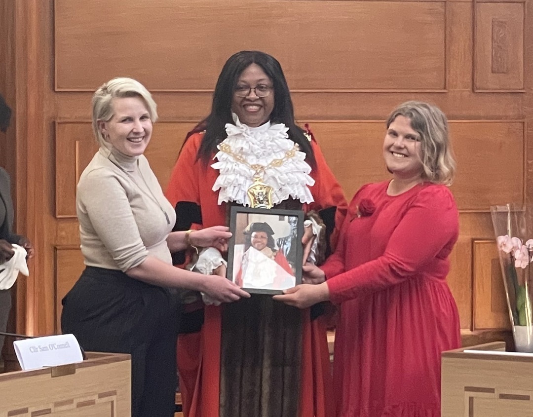 Mayor Elizabeth Baptiste presented with a framed photograph by Conservative group leader Emma Best and Labour council leader Grace Williams. Image: Waltham Forest Council