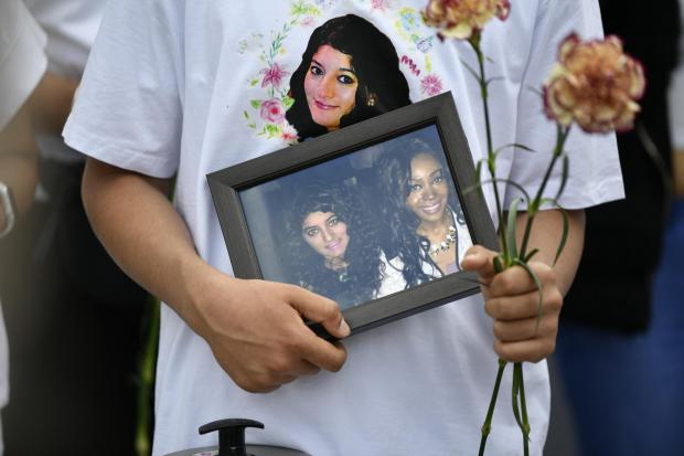 East London and West Essex Guardian Series: A mourner holds a photo of Ms Aleena, left, at the vigil. Credit: PA