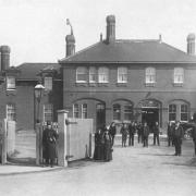 Staff at Chingford Train Station pose for the camera along with a policeman and horse taxi c1890