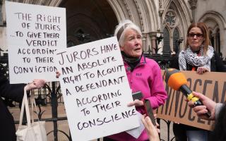 Trudi Warner holding a sign outside the Royal Courts of Justice in London, following a High Court ruling