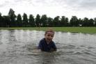 Joshua Thorn, 3, takes a dip in what is normally a cricket pitch in Beverley Park, New Malden